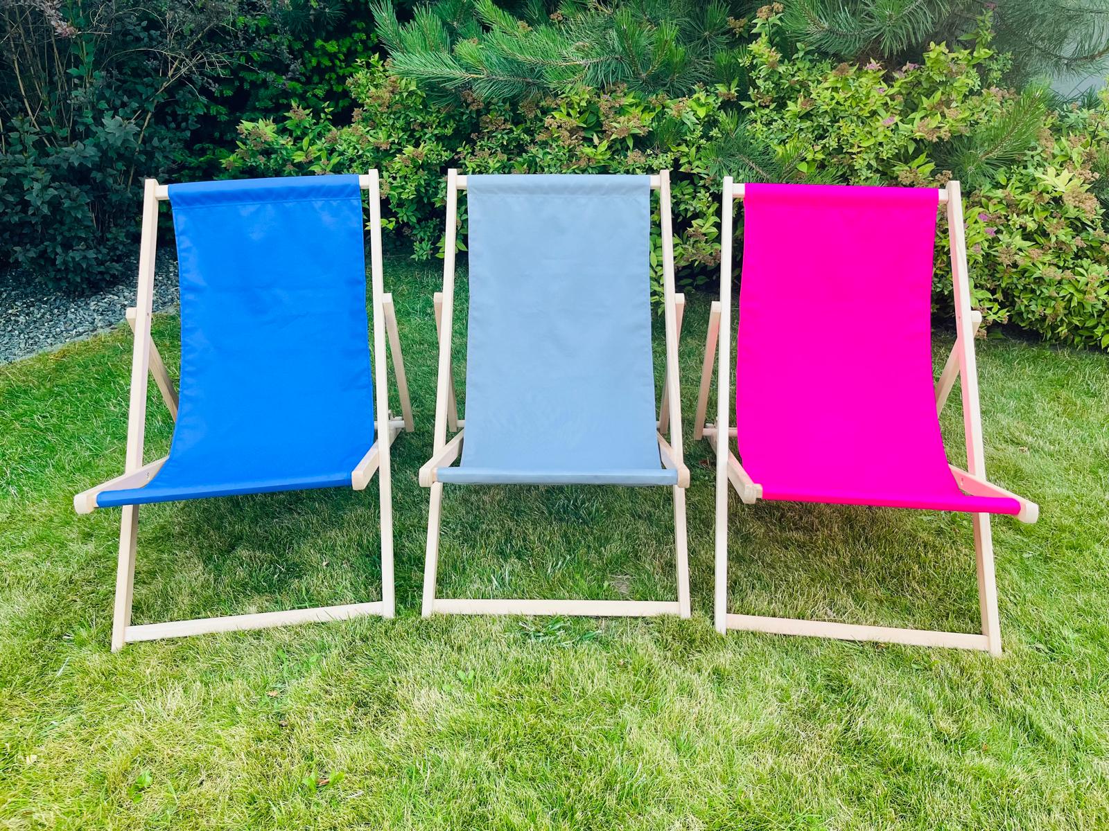 Three promotional loungers set on grass, with fabrics in blue, gray, and pink – ideal for showcasing a logo or company branding.